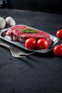39563971 - raw steak with tomatoes, mushrooms and dill.
